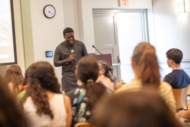 A speaker talks on the mic to a classroom of people in Broad Hall.